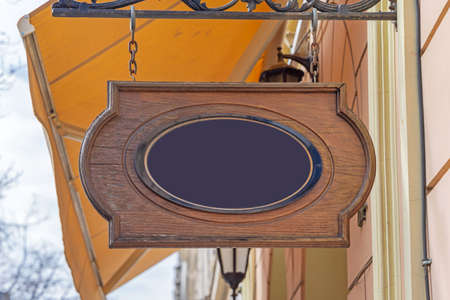 Black Oval at Wooden Board Hanging Sign at Chain Shopの写真素材