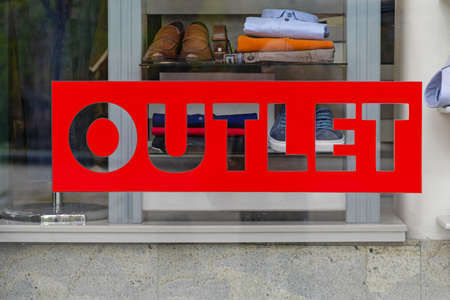 Red Outlet Sign at Clothing Shop Windowの写真素材