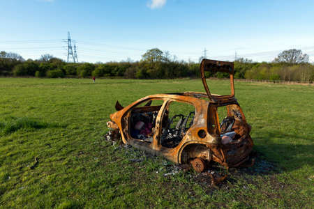 Burned out car in a fieldの写真素材
