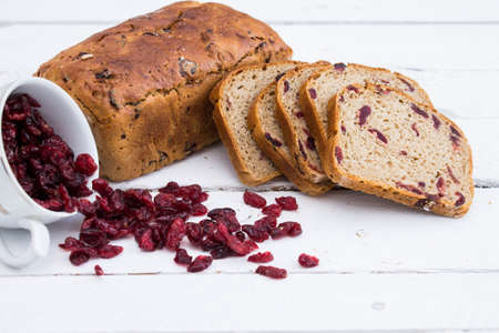 Bread with cranberries on white wooden boardの写真素材
