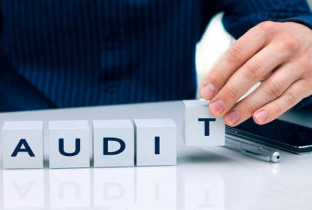 Businessman arranging small blocks with word "Audit"の写真素材