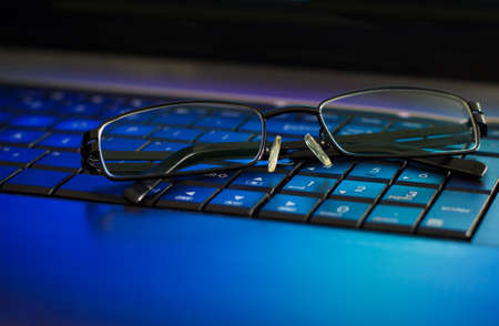 Eyeglasses on laptop keyboard. The concept of caring for eyes and take breaks when working with your computerの写真素材