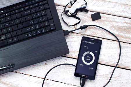 Laptop with pendrive, sd card and smartphone. Concept of data storage.