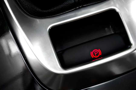 Close-up to a hand brake button in a car.
