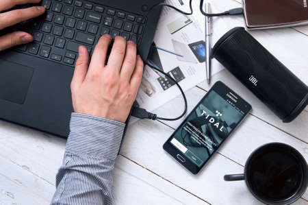 WROCLAW, POLAND- SEPTEMBER 09th, 2016:  Man launches Tidal application on Samsung A5. Tidal is a subscription-based music streaming service that combines lossless audio and high definition musicのeditorial素材