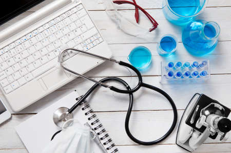Medicine and laboratory tools spreads on white wooden deskの写真素材