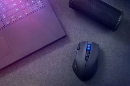 Gaming mouse, portable speaker and laptop at night.の写真素材
