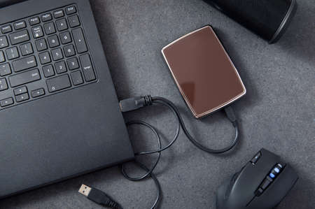 Laptop with connected portable hard drive. Conception of data storage.の写真素材