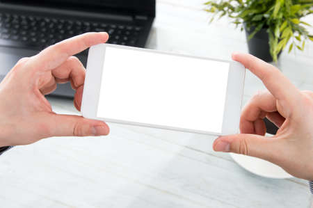 Businessman holds white smartphone with empty screenの写真素材