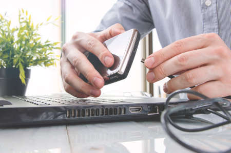 Man is connecting portable disk drive into laptopの写真素材