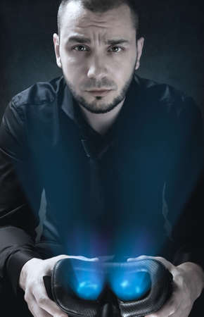 Portrait of businessman that is holding glowing Virtual Reality headset