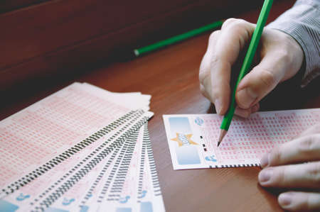 WROCLAW, POLAND -  MARCH 28th, 2017: Man fill out a lotto lottery ticket. Lottery organized by Totalizator Sportowy. It has been in Poland since 1957.のeditorial素材