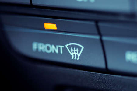 Close-up to the front window heater icon in a modern car