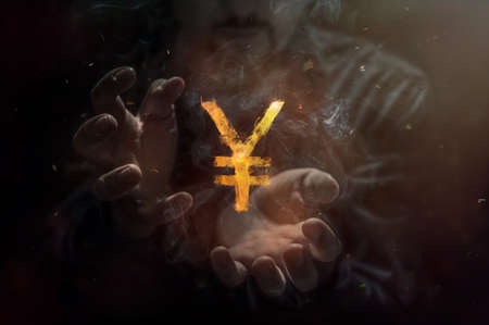 Burning symbol of yen and yuan with man i the background. Conception of risk management in money trading at currency marketの写真素材