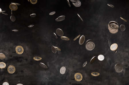 Rain of polish coins on dark backgroundの写真素材