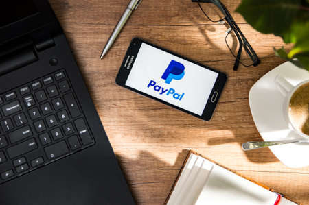 WROCLAW, POLAND - NOVEMBER 17th, 2017: Samsung A5 is laying on the desk with PayPal logo on screen. PayPal Holdings, Inc. is an American company operating a worldwide online payments system that supports online money transfers.のeditorial素材