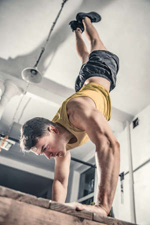 Man performs handstanding at the gym. Photos taken on an atmospheric old gymの写真素材
