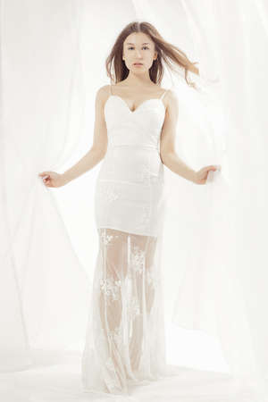 Young woman wearing a wedding dress in a bright studio stylizationの写真素材