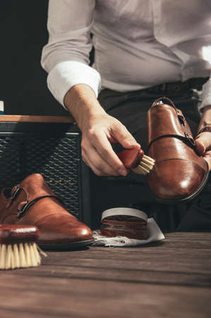 Man applies shoe polish with a small brushの写真素材