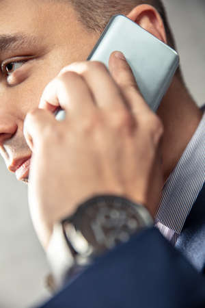 Elegant man is talking on the phone. Vertical orientation of photo