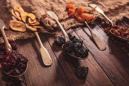 Dried fruits arranged on a spoon, fabric and an old table. Composition in the old styleの写真素材