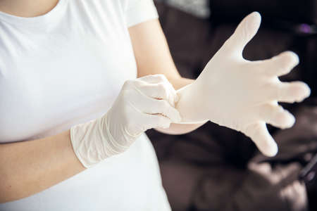 Woman puts on latex gloves that protects from microbesの写真素材