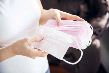 Woman holds a lot of masks that protect from bacteria and virusesの写真素材
