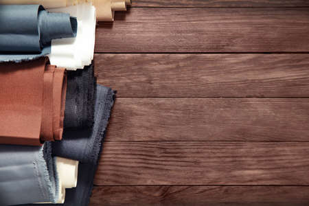 Beles of fabric on wooden background. View from the top.の写真素材