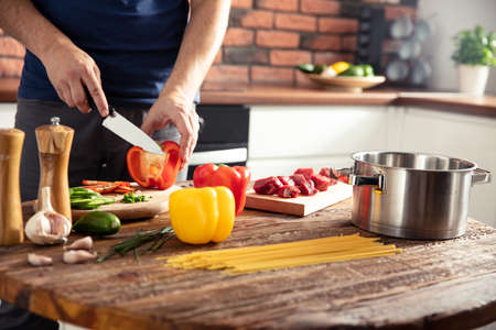 Man preparing delicious and healthy food in the home kitchenの写真素材