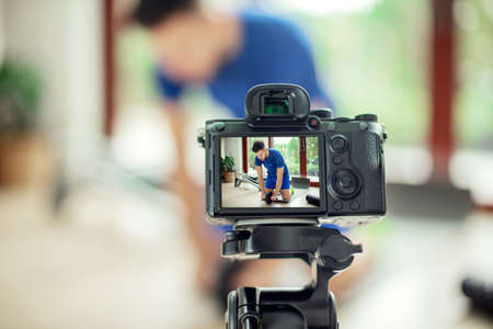 Camera records a man exercising at home. Internet training conceptの写真素材
