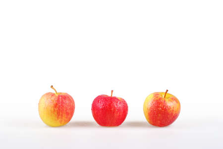 Line of three dewy apples with white backgroundの写真素材