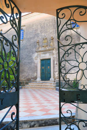 Greek monastery and opened iron ornamental gateの写真素材