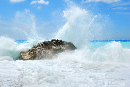 Big sea wave breaking on the shore rocks with a high sea sprayの写真素材