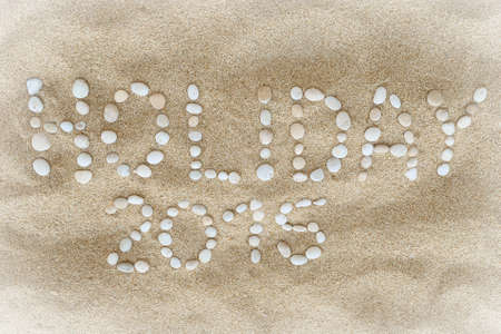 Holiday 2015 headline composed of white pebbles on a beach sandの写真素材