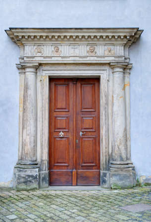 Old monastery portal and brown wooden doorの写真素材