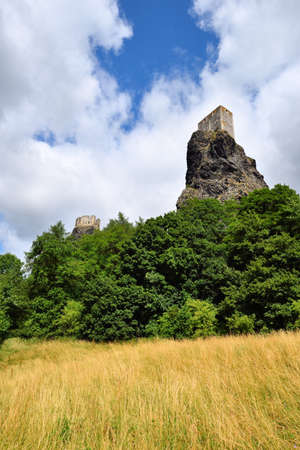 High volcanic cliff with castle towers rising high above the forest treesの写真素材