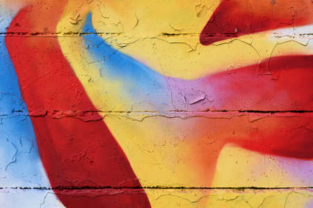 Colorful graffiti sprayed on an old flaky wallの写真素材