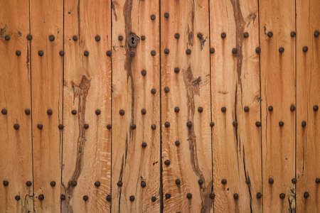 Texture of strong wooden door with big rusty nailsの写真素材