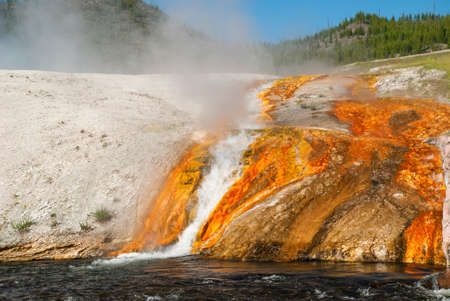 The Steam rising above white-orange banks of Firehole River, Yellowstone National Parkの写真素材