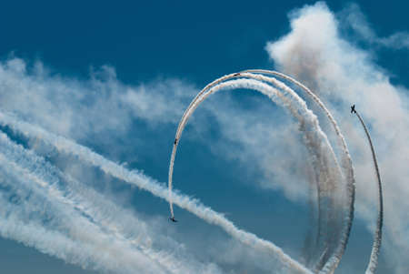 Four sports aircraft are making the loop in the blue skyの写真素材