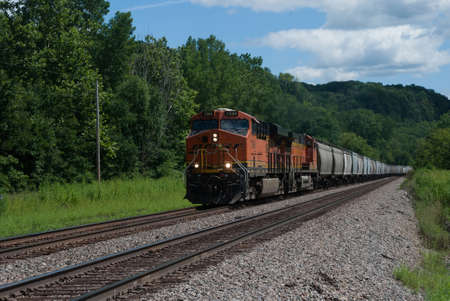 Mississippi Palisades State Park, Savanna, Illinois, USA - August 06, 2016. Freight train is rushing along railway tracksのeditorial素材