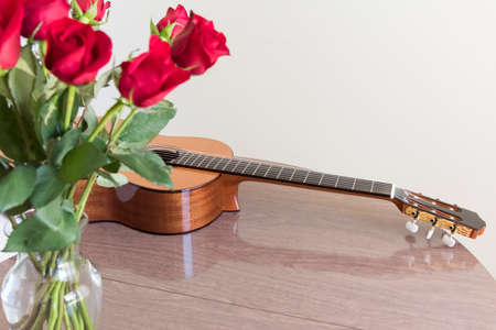 Still life with a bouquet of roses and a guitar