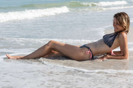 Smiling young pretty woman sunbathing on Sand Key beach, Florida, USAの写真素材
