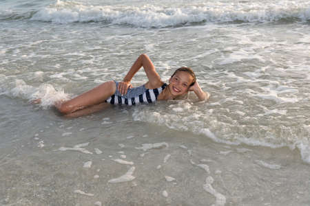 A young girl rejoices the summer and the warm waves of the Gulf of Mexico, Florida, USAの写真素材