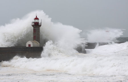Storm waves over the Felgueiras Lighthouse in a cloudy day, Oporto, Portugal.の写真素材
