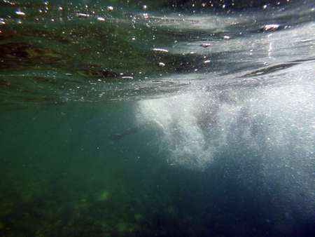 Refreshing dive into the water from underwater viewの写真素材