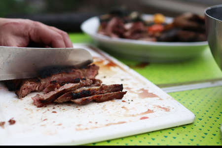 Slicing freshly grilled and juicy steak. Baked steak ribeye medium rare.の写真素材