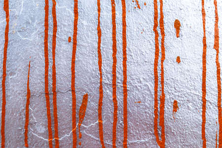 Texture from vertical orange drops of paint on a silver background.の写真素材