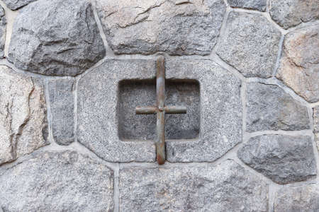 Texture of a stone wall near the harbor and an iron anchor.の写真素材