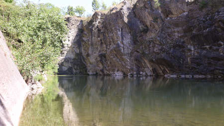 View of a flooded and old limestone mine from the 19th century with beautiful reflections of rocks and trees.の写真素材